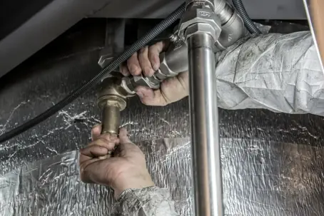 plumber fixes a pipe