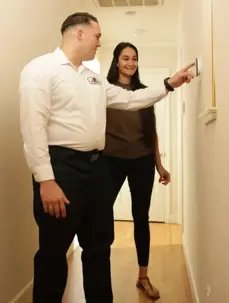 technician uses a thermostat with customer